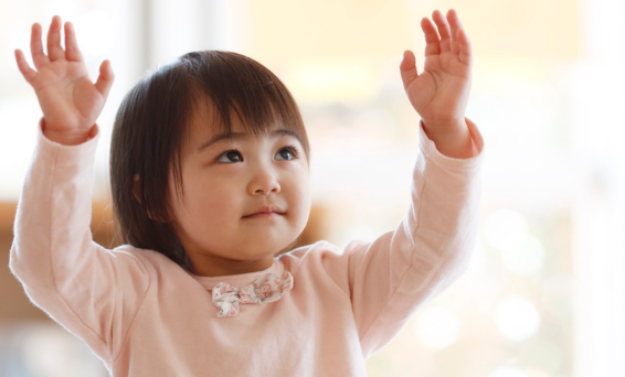 Under 5s child holding hands up