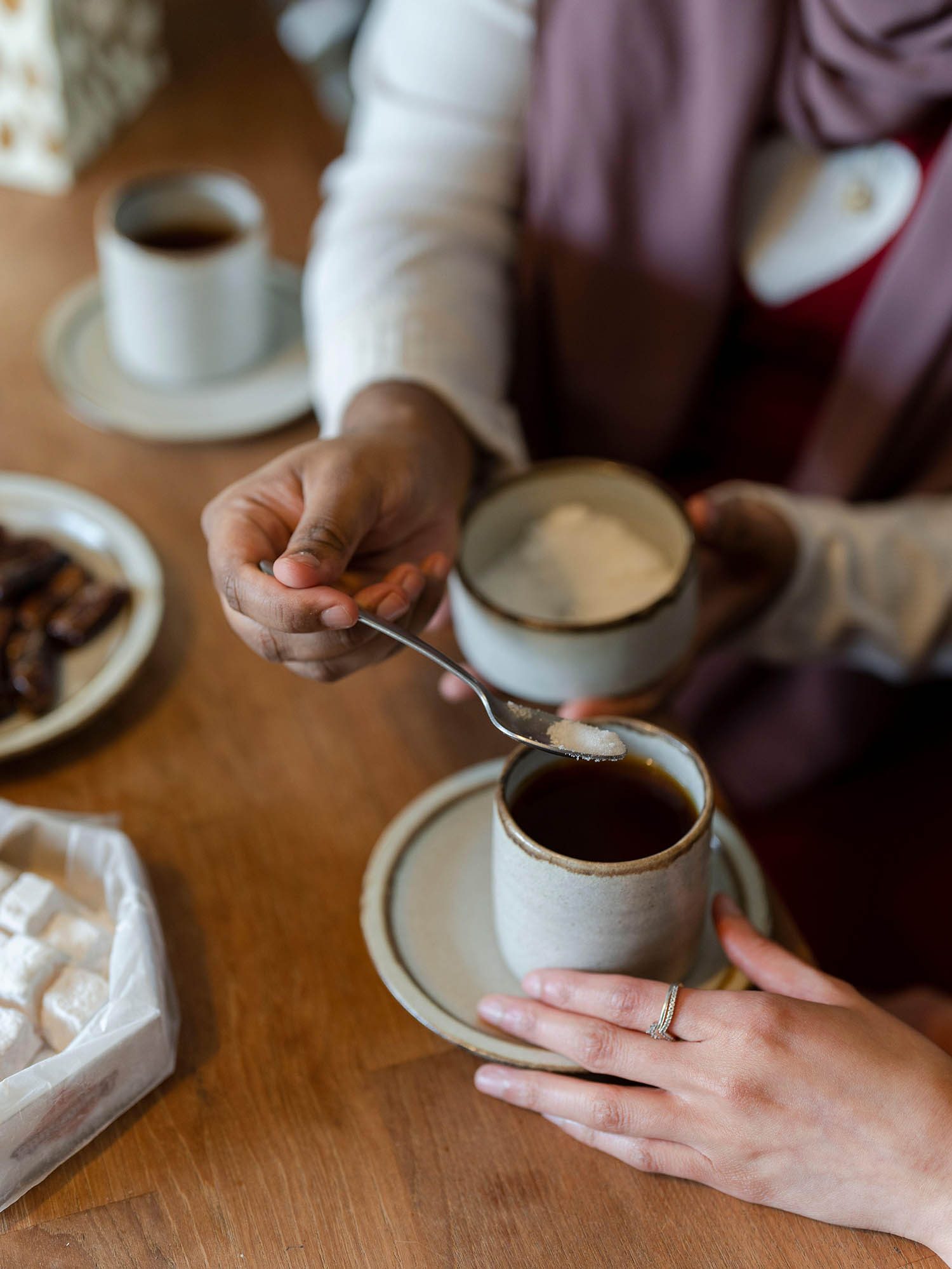 Person serving sugar for coffee