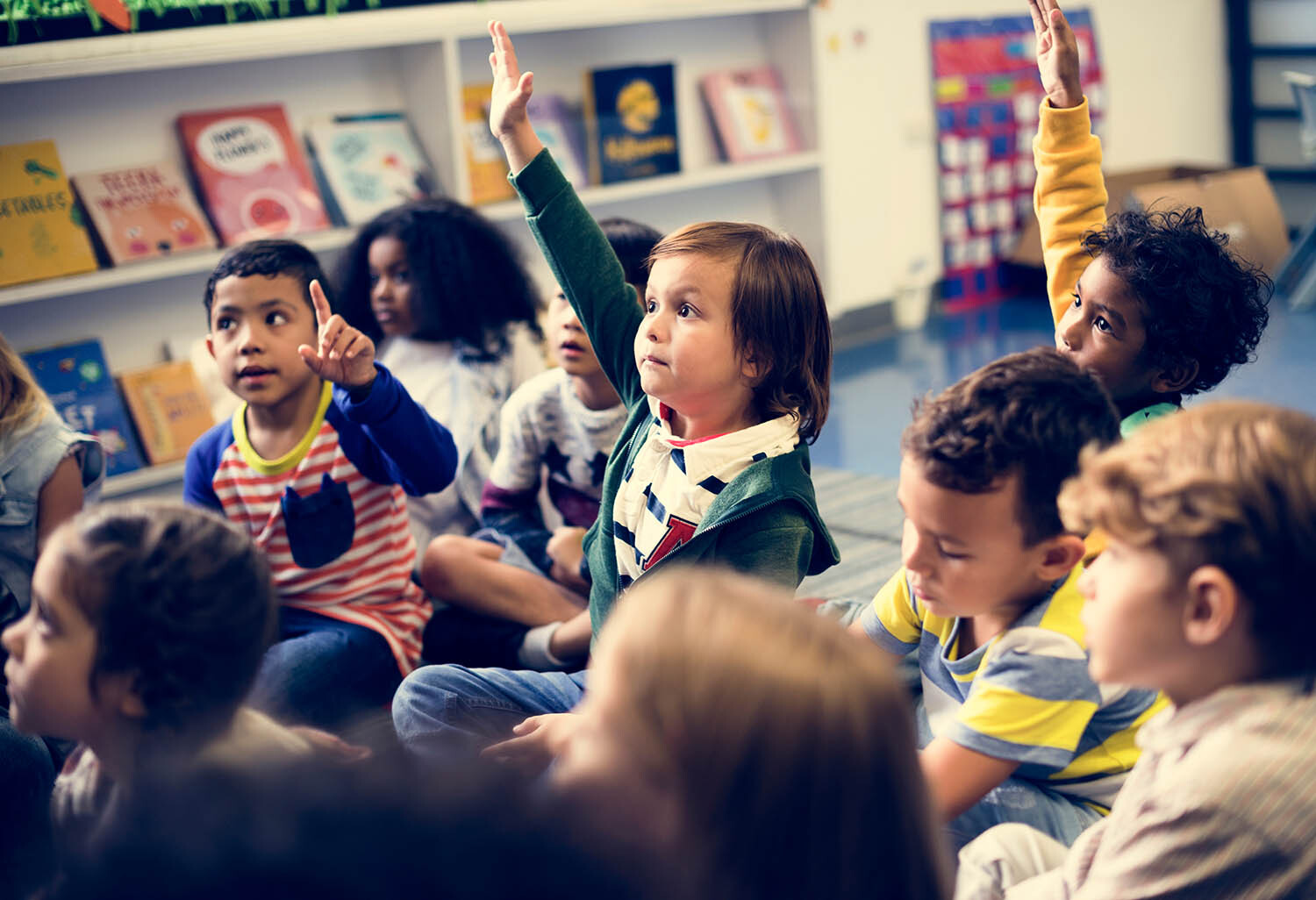 Primary school children with hands up