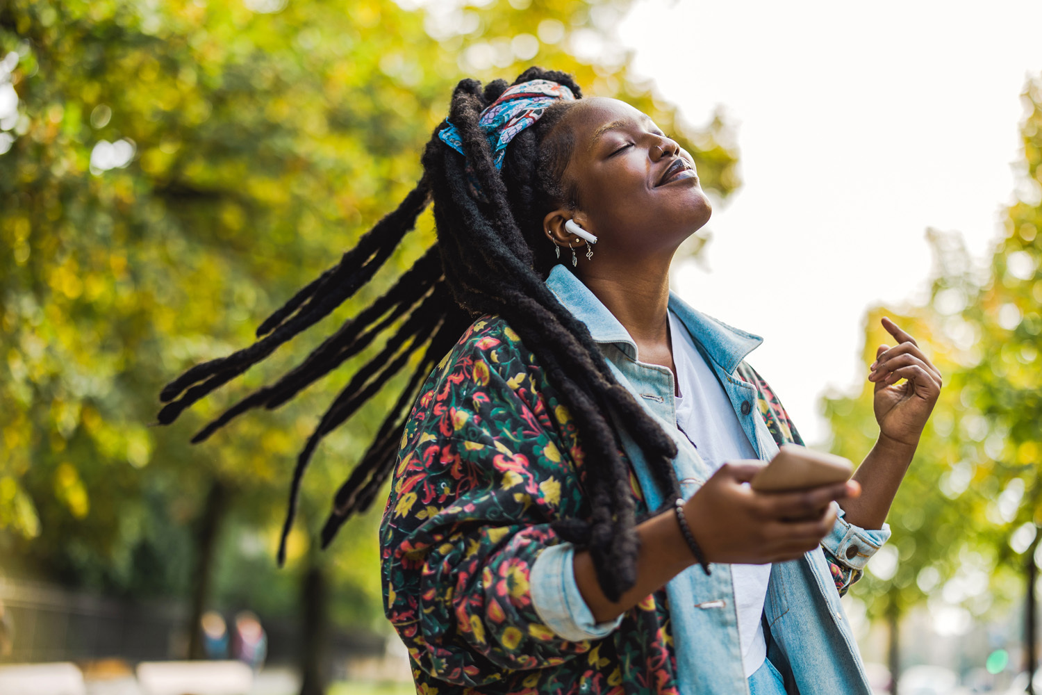 Young black woman dancing to phone