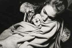 Young woman clutching blanket 250px